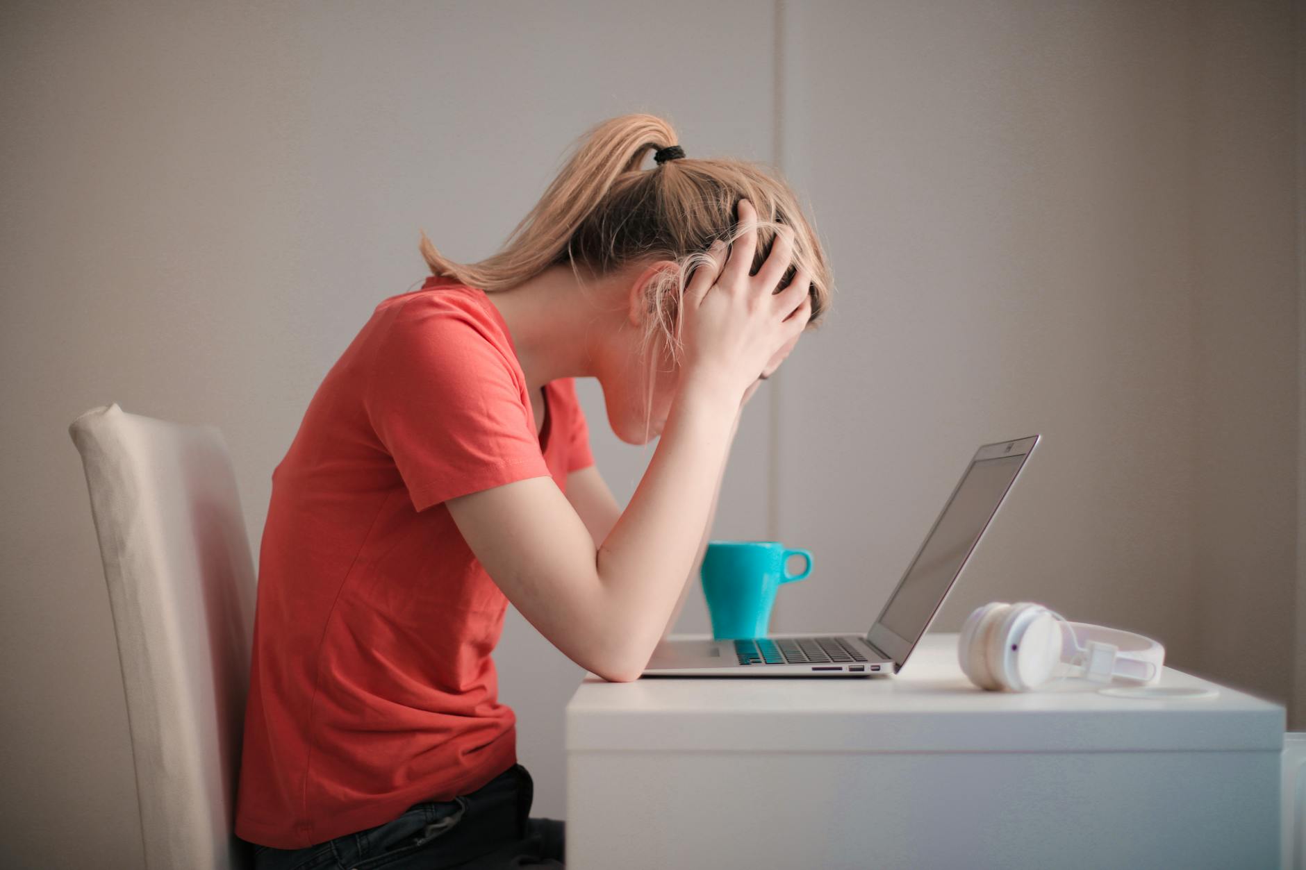 woman in red t shirt looking at her laptop