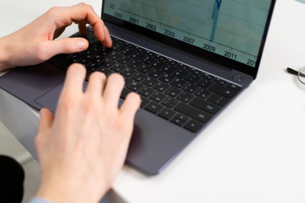 anonymous businessman working on financial project using laptop in office